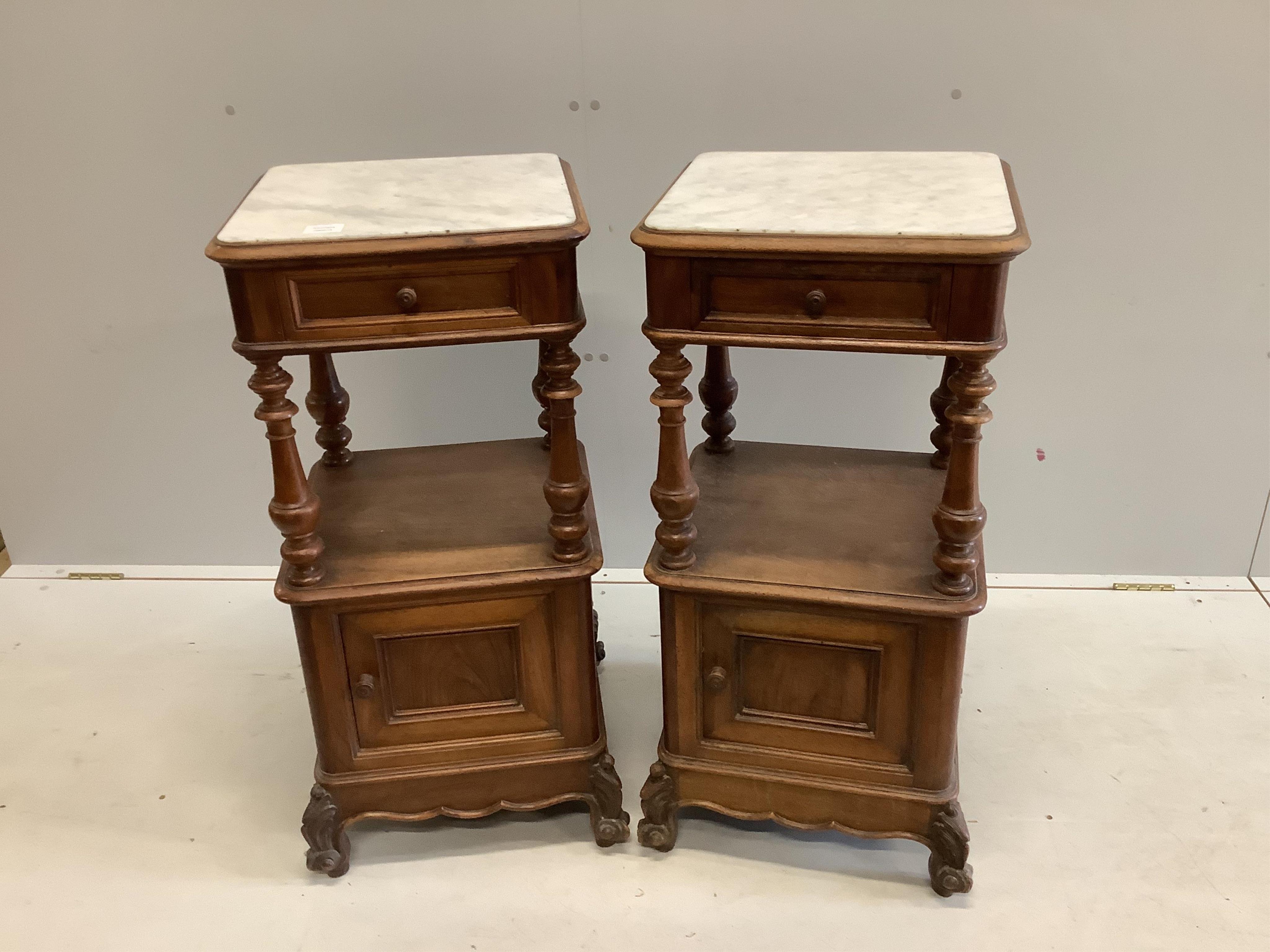 A pair of late 19th / early 20th century French marble top walnut two tier bedside cabinets, width 41cm, depth 41cm, height 89cm. Condition - fair